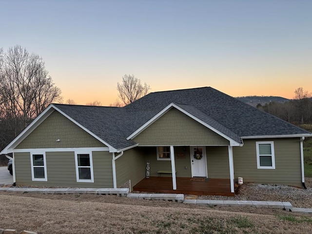 single story home featuring a porch and a shingled roof