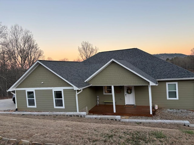 view of front of house featuring covered porch and a shingled roof
