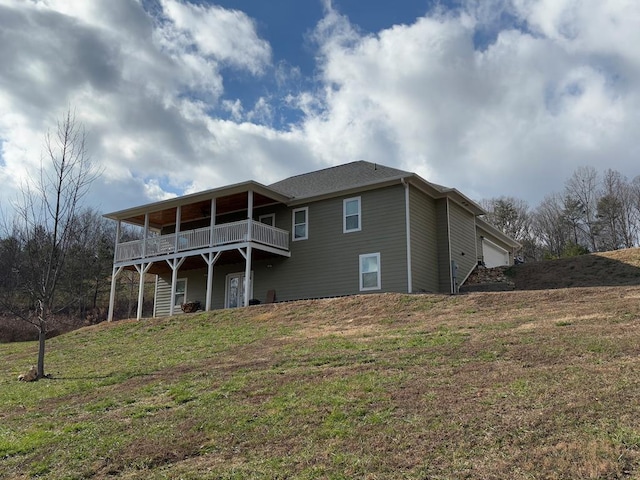 back of property with a garage and a yard