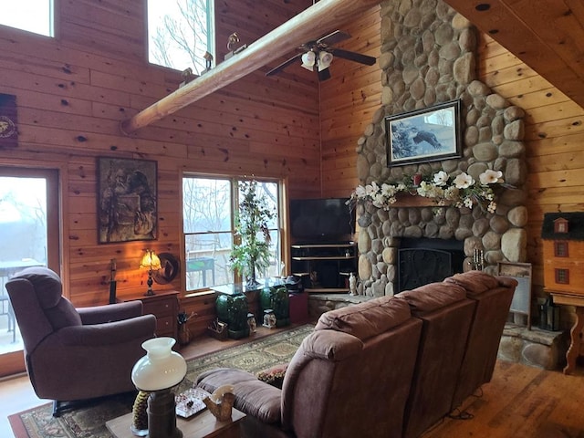 living room featuring hardwood / wood-style flooring, a fireplace, high vaulted ceiling, and wooden walls