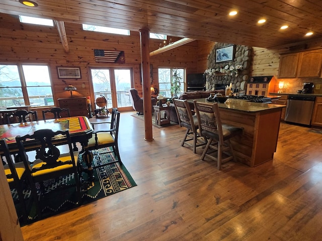 kitchen with wood ceiling, stainless steel dishwasher, dark wood-type flooring, and a breakfast bar area