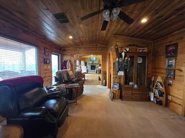 carpeted living room with lofted ceiling, wood walls, wood ceiling, ceiling fan, and a fireplace