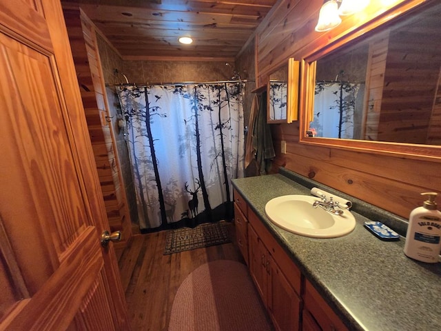 bathroom featuring wooden ceiling, hardwood / wood-style floors, vanity, and wood walls