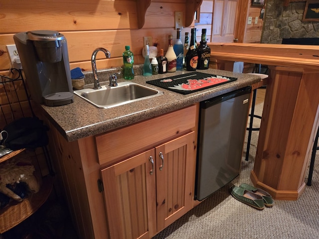 kitchen with carpet flooring, dishwasher, sink, and wood walls