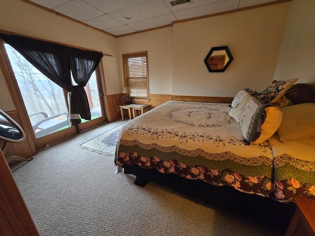 bedroom with crown molding, carpet floors, access to exterior, and wooden walls