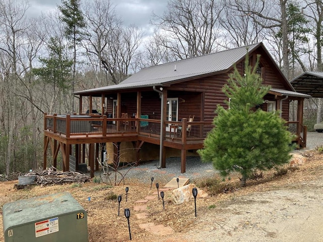 view of front facade featuring a wooden deck and metal roof