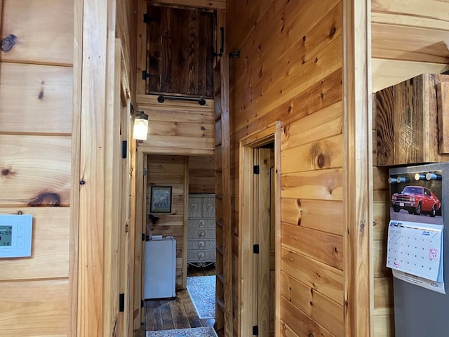 corridor with wood walls and wood finished floors