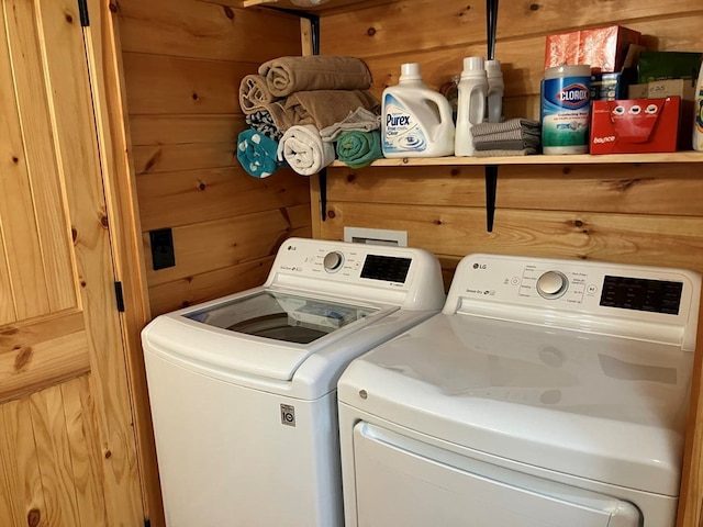 washroom featuring wood walls, independent washer and dryer, and laundry area