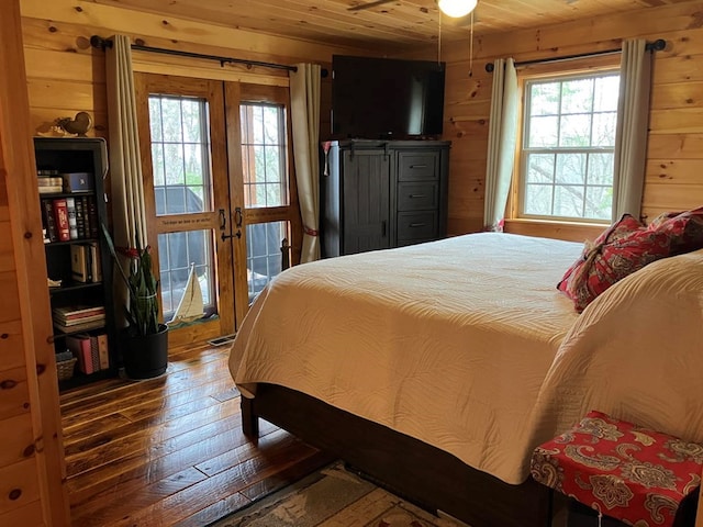 bedroom featuring wooden walls, wood ceiling, and hardwood / wood-style floors