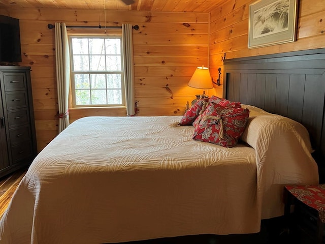 bedroom featuring wooden ceiling and wooden walls