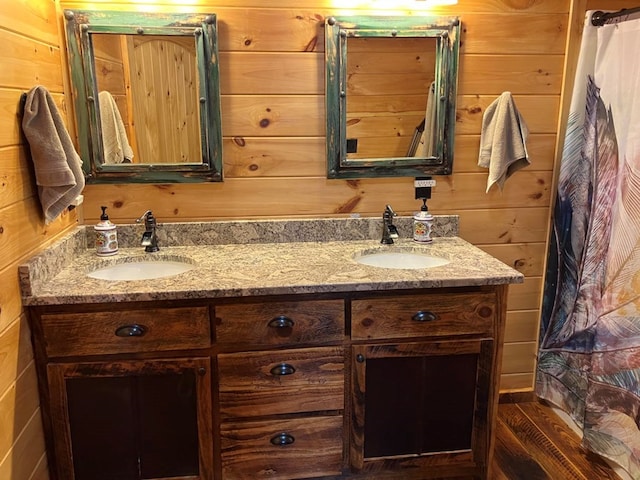 bathroom featuring double vanity, wooden walls, and a sink