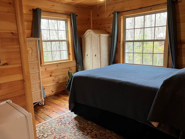 bedroom featuring wooden walls and wood finished floors