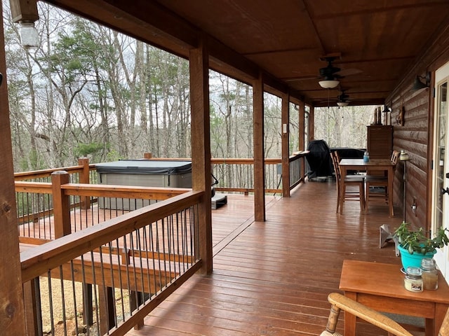 wooden deck with a ceiling fan and a hot tub
