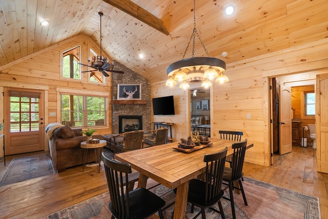 953 Lemmon Ln, Ellijay, GA 30540 - dining room with wooden ceiling, wood-type flooring, a stone fireplace, a ceiling fan, and wooden walls