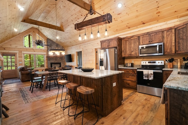 953 Lemmon Ln, Ellijay, GA 30540 - kitchen with stainless steel appliances, open floor plan, a stone fireplace, light wood finished floors, and wooden ceiling with exposed beams
