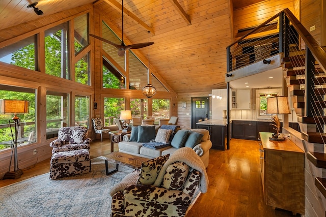 living area featuring a wealth of natural light, light wood-style flooring, and high vaulted ceiling