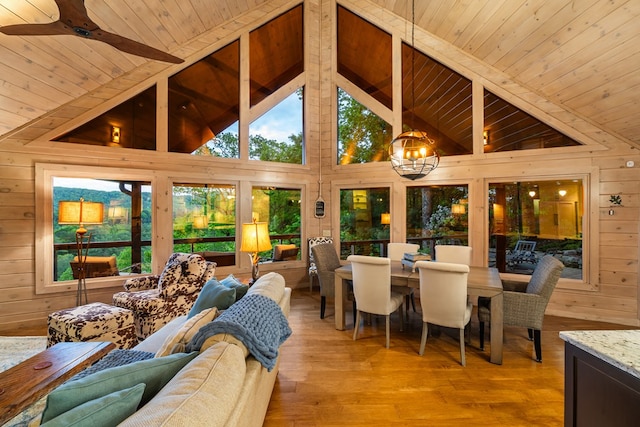 sunroom / solarium featuring a chandelier and beamed ceiling