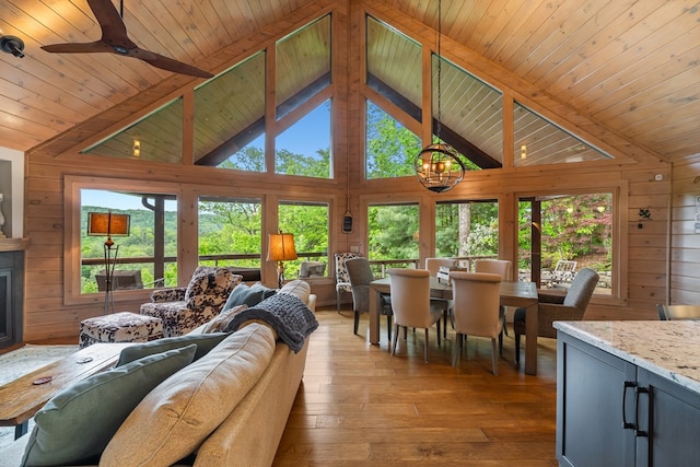 living area featuring a wealth of natural light, hardwood / wood-style floors, beam ceiling, and wood ceiling