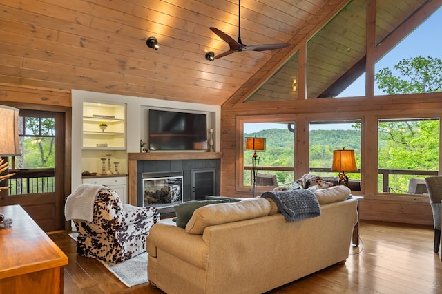living room with lofted ceiling, wood walls, hardwood / wood-style floors, wooden ceiling, and a fireplace