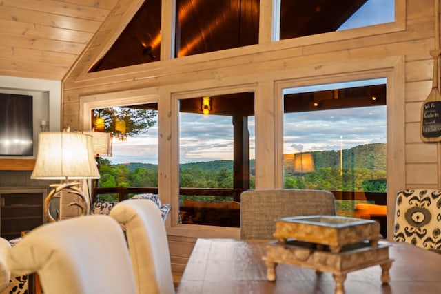 interior space with a wealth of natural light, wooden walls, wooden ceiling, and vaulted ceiling