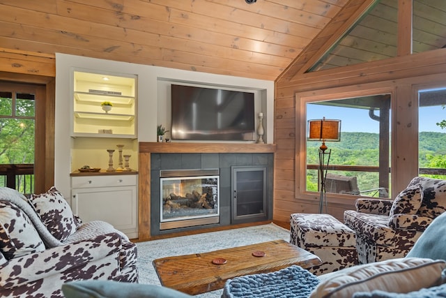 living room with wooden ceiling, lofted ceiling, a tiled fireplace, and wood walls