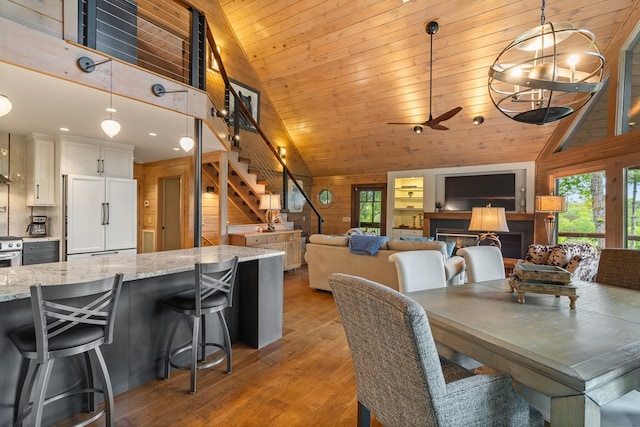 dining area with stairs, high vaulted ceiling, wooden ceiling, light wood-style flooring, and a ceiling fan