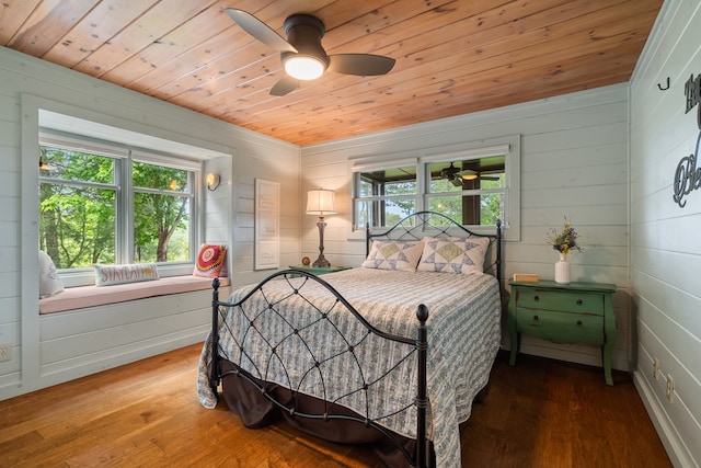 bedroom with wooden walls, ceiling fan, wooden ceiling, and wood finished floors