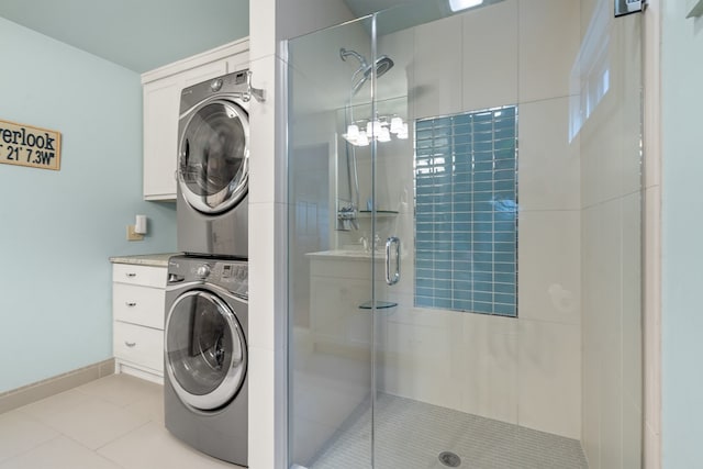 bathroom with a stall shower, stacked washer and dryer, tile patterned flooring, and baseboards