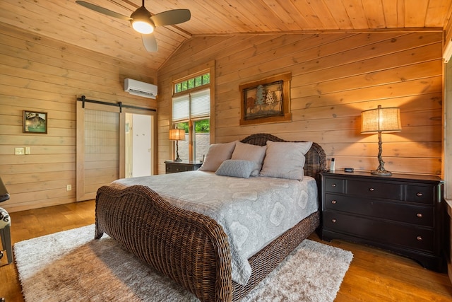 bedroom featuring wood walls, a barn door, vaulted ceiling, a wall unit AC, and wood ceiling