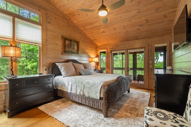 bedroom featuring lofted ceiling, access to outside, wood walls, and wood finished floors