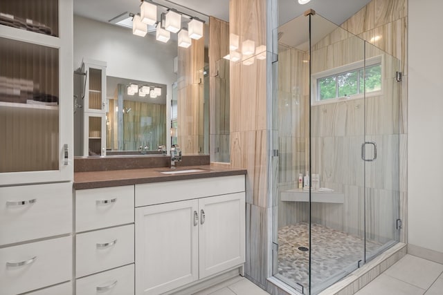 bathroom featuring tile patterned flooring, a shower stall, and vanity