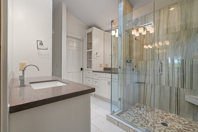 bathroom featuring vanity, a shower stall, and tile patterned flooring