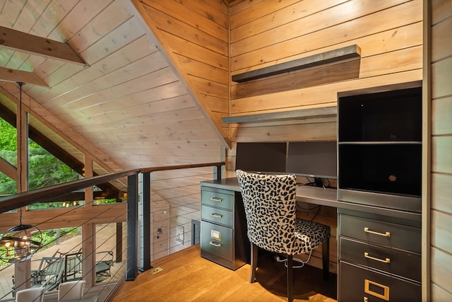 office space featuring wooden walls, light wood finished floors, and built in study area