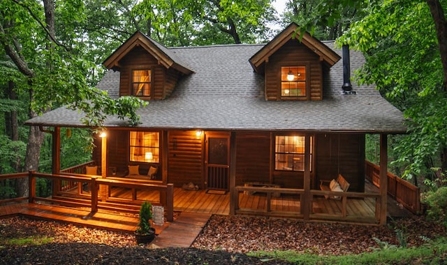 rear view of property with roof with shingles and log veneer siding