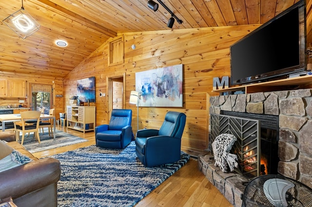 living room featuring a stone fireplace, hardwood / wood-style flooring, wooden walls, and wooden ceiling