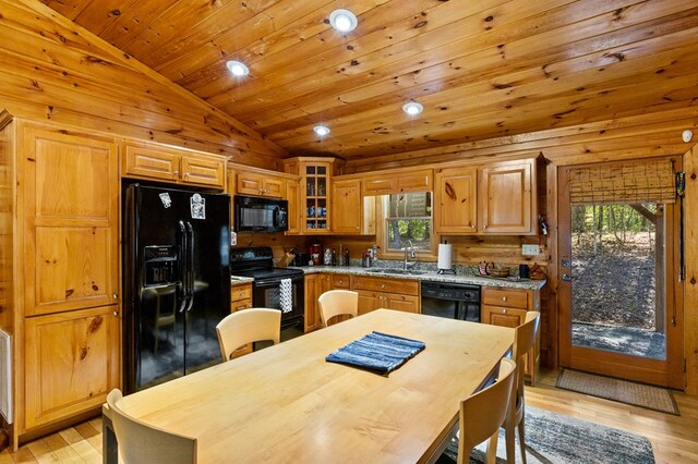 kitchen with sink, light hardwood / wood-style flooring, vaulted ceiling, and black appliances