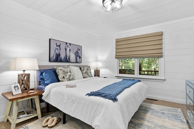 carpeted bedroom with wood walls