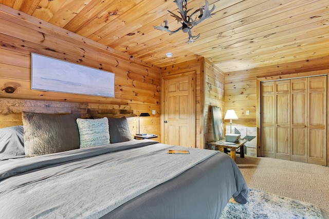 bedroom with wood walls, a closet, wooden ceiling, carpet flooring, and a skylight