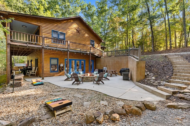 rear view of property featuring a patio area and an outdoor fire pit