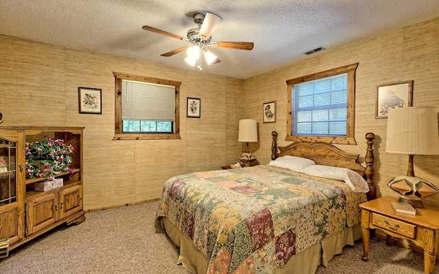 carpeted bedroom with a textured ceiling and ceiling fan