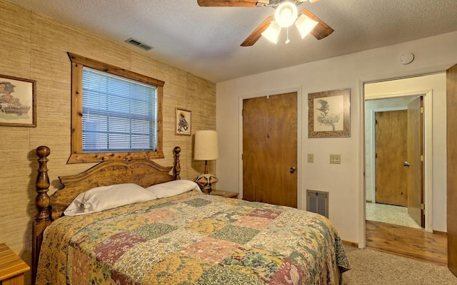 bedroom with carpet flooring, ceiling fan, a textured ceiling, and a closet