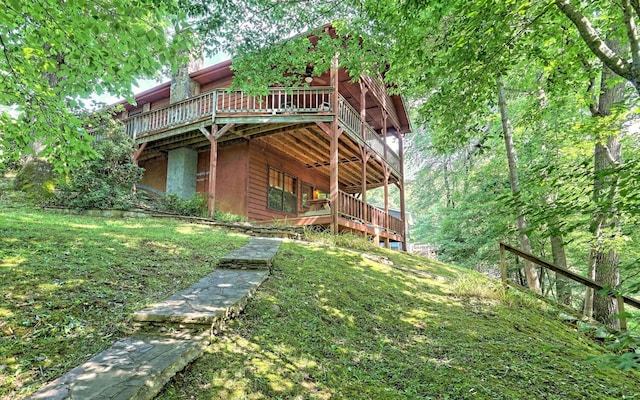 rear view of house featuring a deck and a lawn