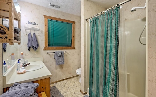 bathroom with a shower with shower curtain, vanity, toilet, and a textured ceiling