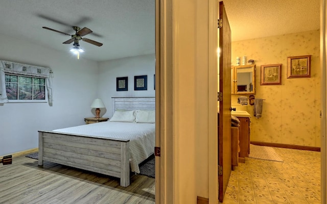 bedroom featuring ceiling fan, light wood-type flooring, and a textured ceiling