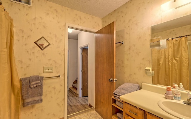 bathroom with vanity, hardwood / wood-style floors, and a textured ceiling