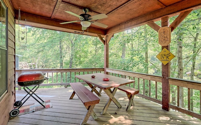 wooden deck featuring ceiling fan and a grill