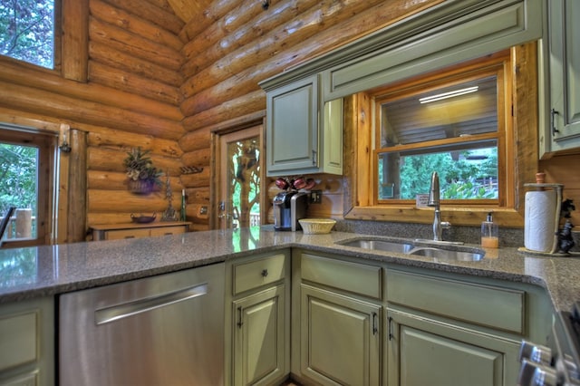 kitchen with green cabinetry, dishwasher, sink, dark stone counters, and rustic walls