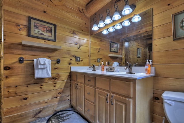 bathroom featuring vanity, toilet, and wooden walls