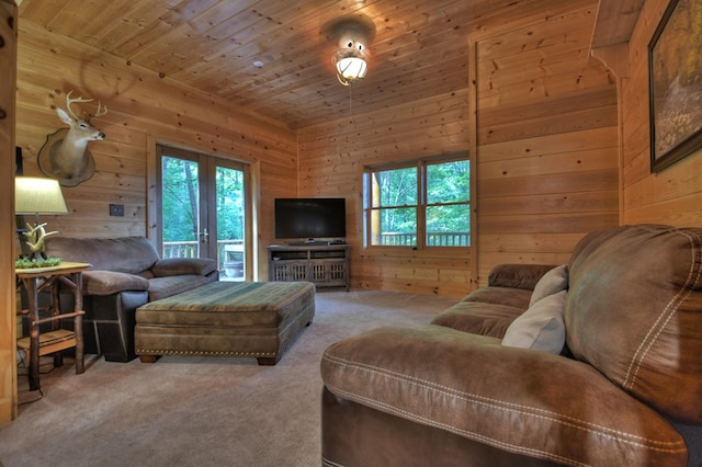 carpeted living room featuring a wealth of natural light, wood walls, and wooden ceiling