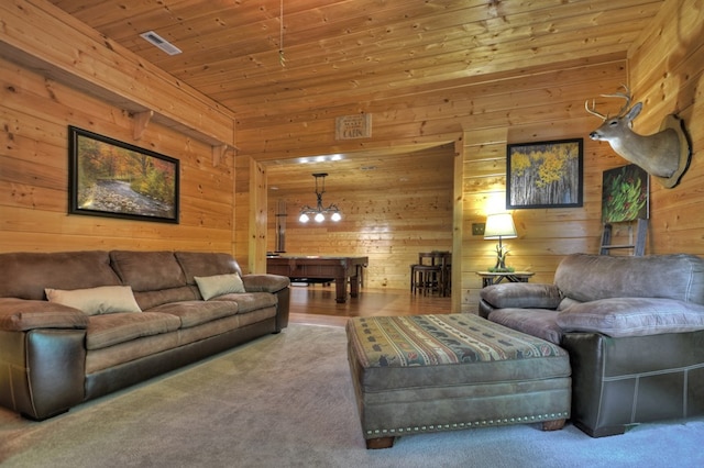 living room with wood ceiling, carpet, wooden walls, and a chandelier